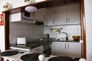 卡门港Casa Regla的厨房配有白色橱柜、水槽和微波炉