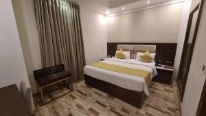 艾哈迈达巴德Regenta Inn Ranip Ahmedabad的一间设有大床和窗户的酒店客房