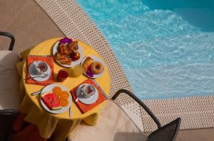 利帕里阿奇杜卡大酒店的游泳池旁带餐盘的桌子