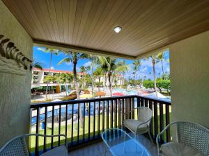 嘎林海斯港Marulhos Muro Alto, Apartamento Encantador的享有游泳池和棕榈树景致的阳台