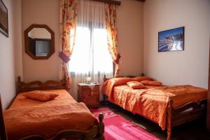 埃拉蒂特里卡隆姆普利兹斯客房旅馆的一间卧室设有两张床、镜子和窗户