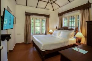 Fort KochiMAI HOUSE HERITAGE HOTEL的一间带一张大床的卧室,位于带窗户的房间内