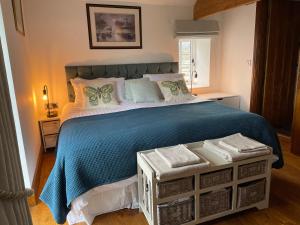 贝克韦尔Long Roods cottage的一间卧室配有一张带蓝色毯子的大床