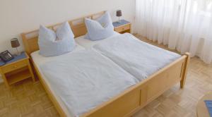 宁布雷希特Hotel im Homburger Ländchen的一间卧室配有两张带白色床单和枕头的床。