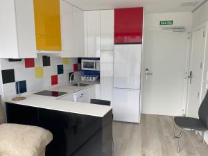 马德里Ekilibrio Hotel & Apart-Suites的厨房配有白色橱柜和白色冰箱。