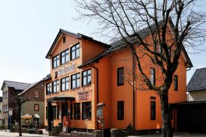 奥伯霍夫Konsum Gästehaus Quisisana - Nebenhaus Berghotel Oberhof - nur Übernachtung的一座橘色的建筑,前面有一棵树