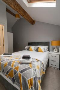 SoutergateQuinta Cottage的一间卧室配有一张大床,配有黄色和灰色的被子