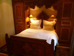 Gundershoffen红磨坊酒店的一间卧室配有一张带两个枕头的大木床