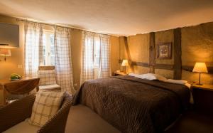 Gundershoffen红磨坊酒店的卧室配有1张床、1张桌子和1把椅子