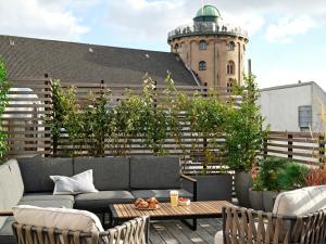 哥本哈根Apēron Apartment Hotel的一个带沙发和桌子的庭院和一座建筑