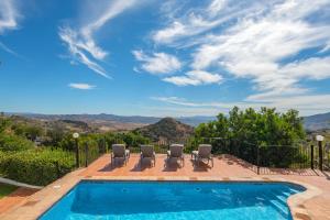 埃尔乔罗La Casa de Alejandro的一个带椅子的游泳池,享有山景