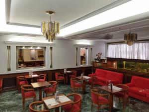 比雷埃夫斯萨沃伊酒店的餐厅配有红色家具和桌椅