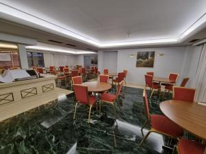 比雷埃夫斯萨沃伊酒店的一间在房间内配有桌椅的餐厅