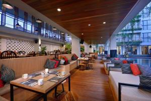勒吉安Hotel NEO+ Kuta Legian by ASTON的一间带沙发和桌椅的餐厅