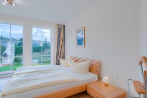 蒂索Strandhaus Thiessow Whg_ 1的白色的卧室设有床和窗户