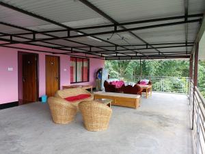 佩林Wind Valley Homestay的客厅配有柳条家具和粉红色的墙壁