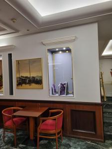 比雷埃夫斯萨沃伊酒店的配有桌椅和镜子的客房