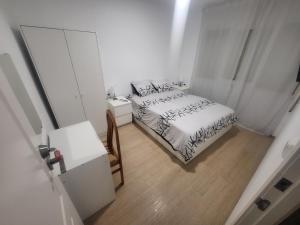 巴达洛纳Habitaciones con baño compartido en bonito Apartamento en Badalona的一间卧室配有一张床、一张桌子和一面镜子