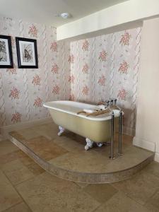 HatherleighThe George Inn的带浴缸的浴室和花卉壁纸