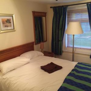 北安普敦格拉夫顿客房酒店的一间卧室配有一张床,床上有毛巾