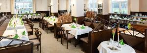维斯马Lübsche Thorweide的用餐室配有桌椅和白色的桌布