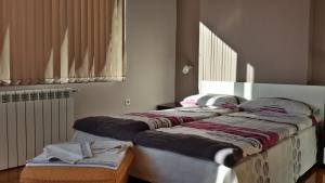 萨帕雷瓦巴尼亚Kyurkchievi Guest House的两张睡床彼此相邻,位于一个房间里