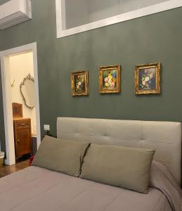 锡拉库扎Ortigia Twin Rooms的客厅配有沙发,墙上挂有四幅画作