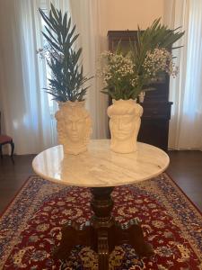 锡拉库扎Ortigia Twin Rooms的两个花瓶坐在桌子上,上面有鲜花