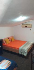 蒂瓦特Apartment Matkovic的一间卧室配有带橙色床单和黄色枕头的床。