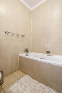 NongomaNongoma Lodge & Inn CC的带浴缸和白色地毯的浴室