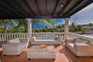 棕榈滩火太阳海岸高尔夫度假酒店的一个带藤椅和桌子的门廊