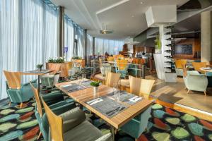 布尔诺Quality Hotel Brno Exhibition Centre的一间带木桌和椅子的餐厅和一间自助餐厅