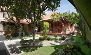 沙努尔巴厘岛尼撒沙努尔酒店的院子里有树木和植物的房子
