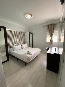 胡米利亚Hostal Fuente del Pino的白色卧室配有床和镜子