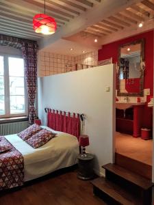 沙托沙隆Maison d'Eusébia的一间设有床铺的卧室,位于一个红色墙壁的房间