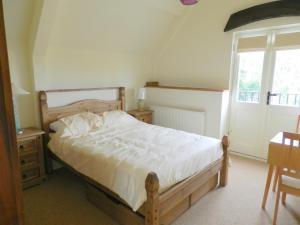 奇平卡姆登Cotswold Charm George Barn的一间卧室设有一张大床和一个窗户。