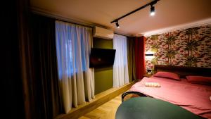 第比利斯Anbani Apartments - City Center的一间卧室设有一张床、一台电视和一个窗口。
