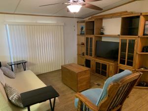 拉瓦卡港Edgewater Getaway的客厅配有电视和桌椅