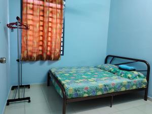 北根Homestay Pekan Pahang Semi D的蓝色墙壁间的一张床位