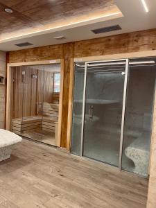 兹拉蒂博尔NEO Apartman的一间设有玻璃门的房间和一间带浴缸的房间