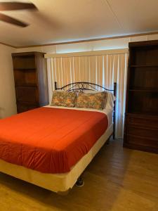 拉瓦卡港Edgewater Getaway的一间卧室配有一张带橙色床罩的床