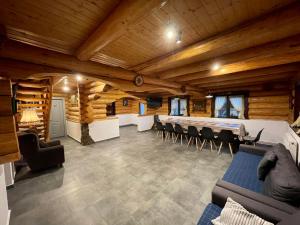 莱斯诺夫Cabana din Groapa Frumoasa的一间带木制天花板的客厅和一间带椅子的房间