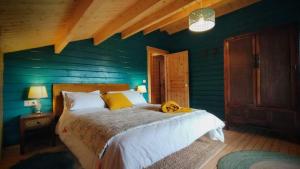 Solana de ávilaCasa rural El Bujo的一间卧室配有一张带蓝色墙壁的大床
