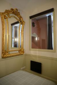 南希Le Stanislas, un style!的一间设有镜子的客房,墙上配有电视