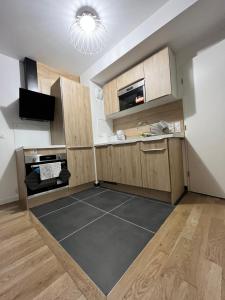 布洛涅-比扬古Superbe appartement de 51m2 à 10mn de Paris的厨房设有木制橱柜和黑色地板。