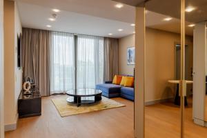 杜塞尔多夫Fourty Three Luxury Serviced Apartments的客厅配有蓝色的沙发和桌子