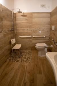 维罗纳Agriturismo Ponte Florio的浴室配有卫生间、椅子和浴缸。