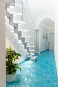 阿马尔菲Amalfi Ammorè的客房铺有蓝色地板,设有白色楼梯。