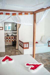 江比阿Dhow Resort的一间卧室配有两张红色鲜花的床。