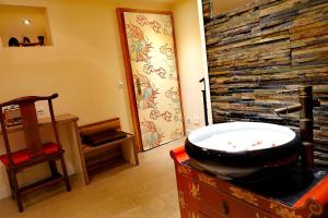 霍其多夫Hotel JiuDing的一间带石墙和浴缸的浴室